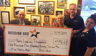 YLD members accepting a large check from Mission BBQ