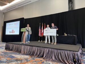 Michael Hildebrabd, YLD President, accepts donation from David Massingham of 908 Devices at IAFC HazMat Conference.